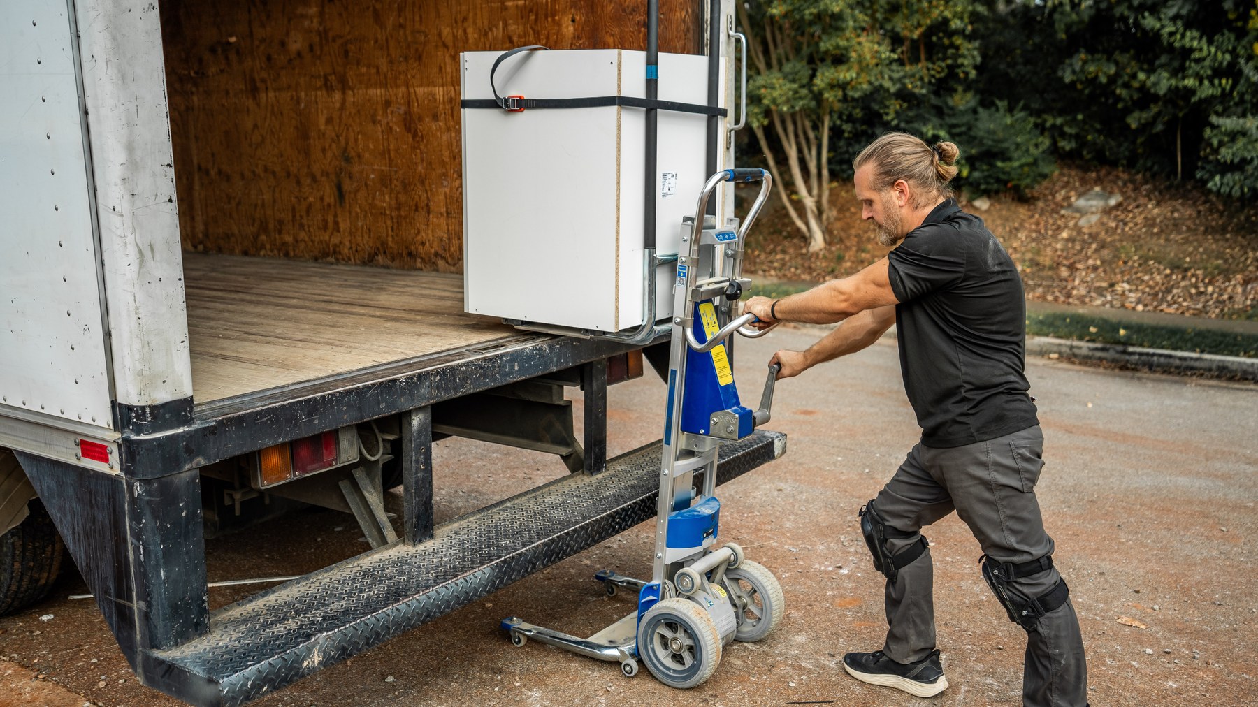 Installer unloading a cabinet from a box truck liftgate with the LiftKar Cabinet Pro