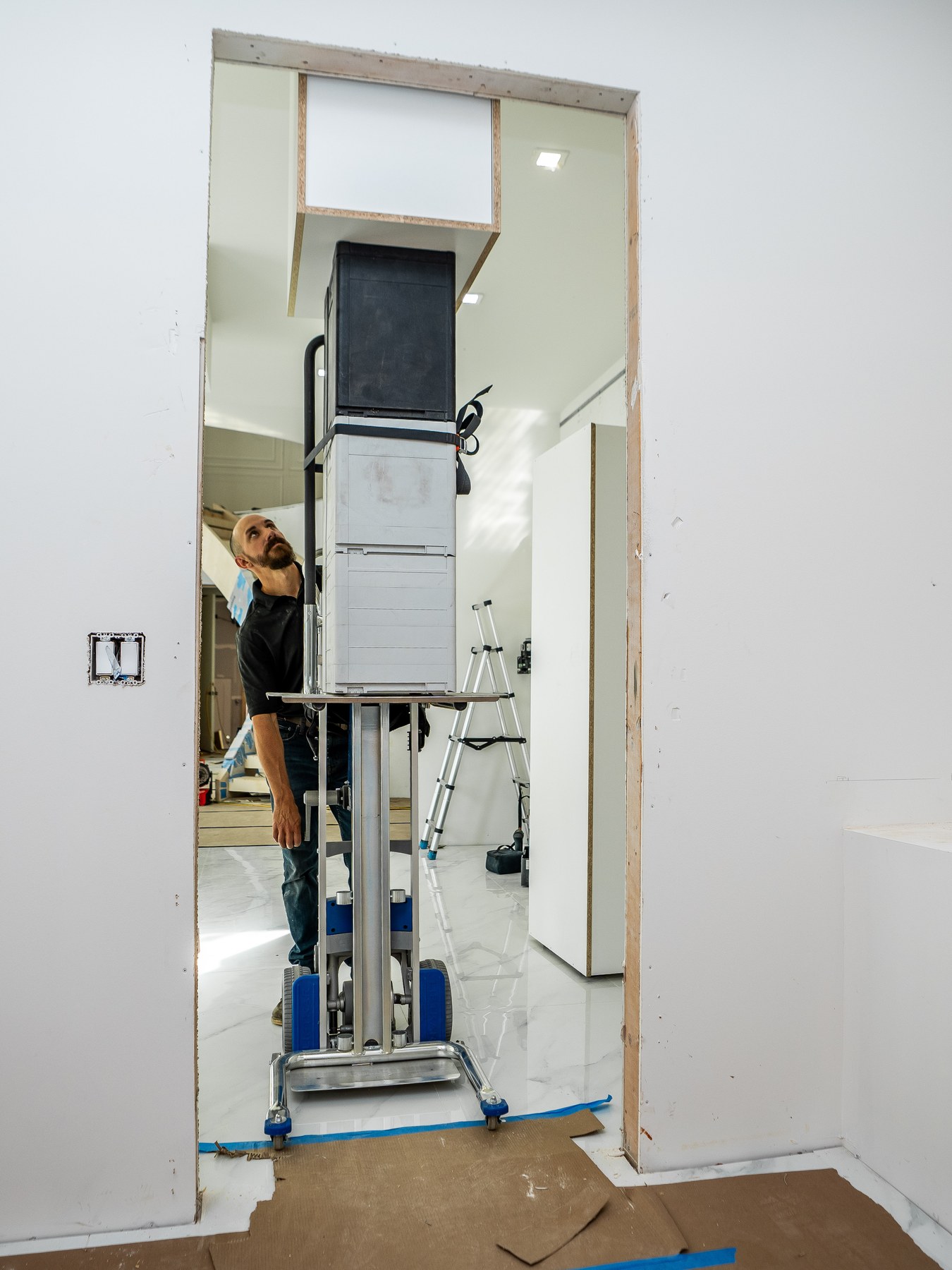 Installer guiding a tall cabinet through a doorway on the LiftKar Cabinet Pro