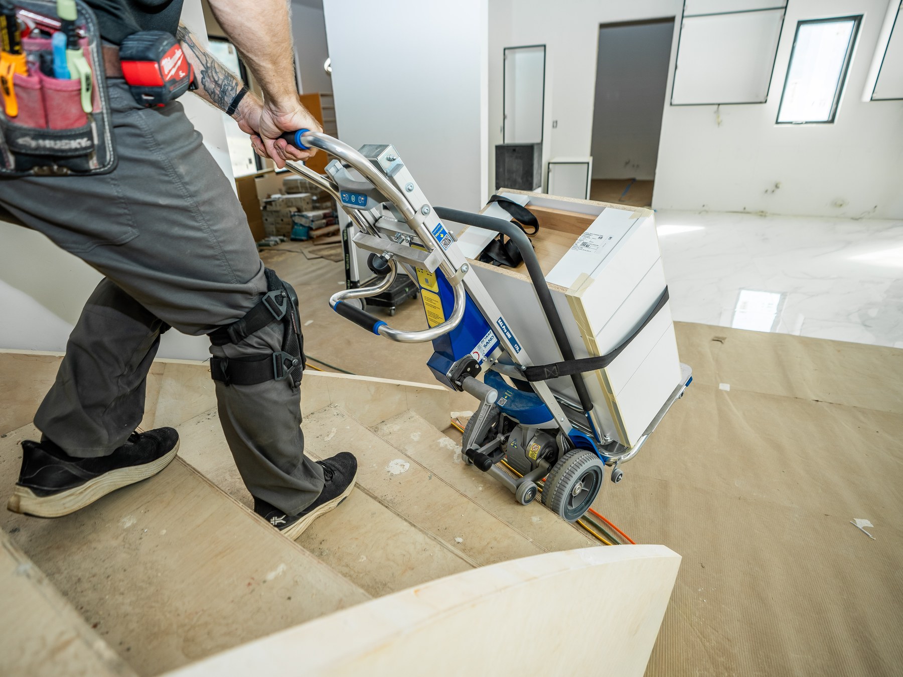 Close-up of the LiftKar Cabinet Pro climbing stairs with a strapped cabinet