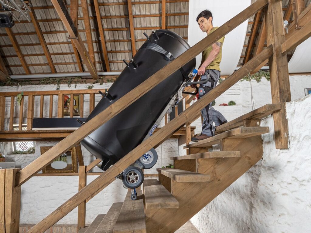 LiftKar HD Pro carrying a boiler up wooden attic stairs
